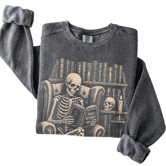 Folded Pepper sweatshirt with a skeleton reading Tales Beyond to a Bulldog
