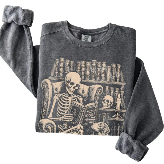 Folded Pepper sweatshirt with a skeleton reading Tales Beyond to a Pointer