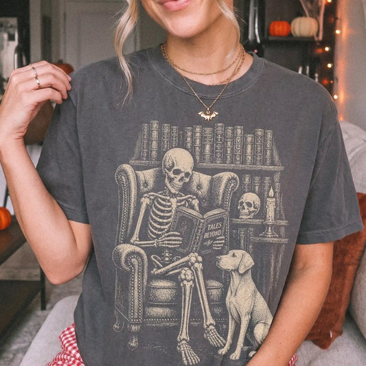 Model wearing a Pepper Comfort Colors® T-shirt showing skeleton reading in a library beside a Vizsla