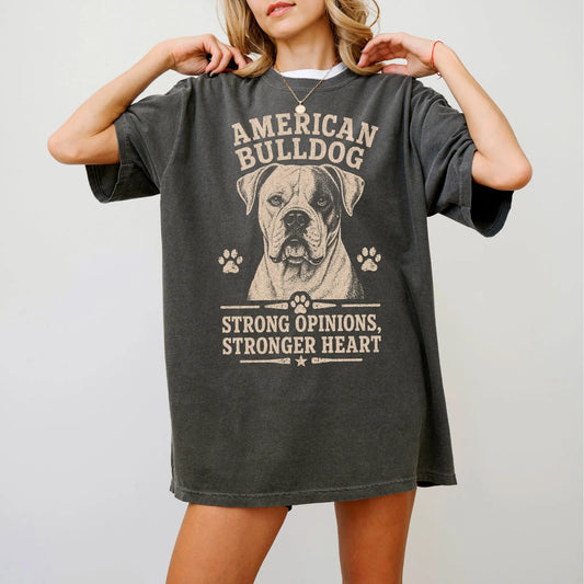 Model wearing a Pepper Comfort Colors® T-shirt featuring American Bulldog design with “Strong Opinions, Stronger Heart” lette