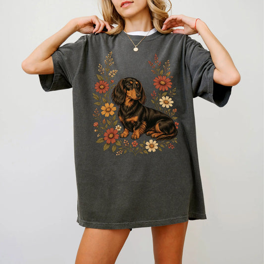 Model wearing a Pepper Comfort Colors® T-shirt showing Dachshund portrait surrounded by wildflowers beneath the moon