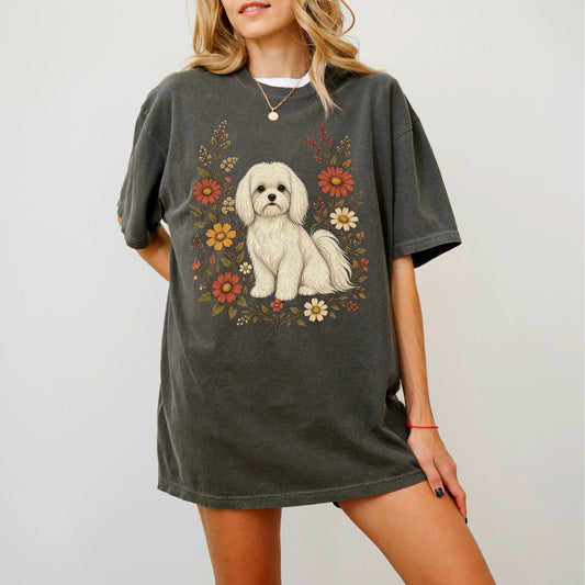 Model wearing a Pepper Comfort Colors® T-shirt showing Maltese portrait surrounded by wildflowers beneath the moon