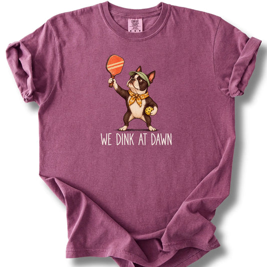 Boston Terrier with a pickleball paddle and ball on a Berry Comfort Colors® T-shirt with We Dink at Dawn text