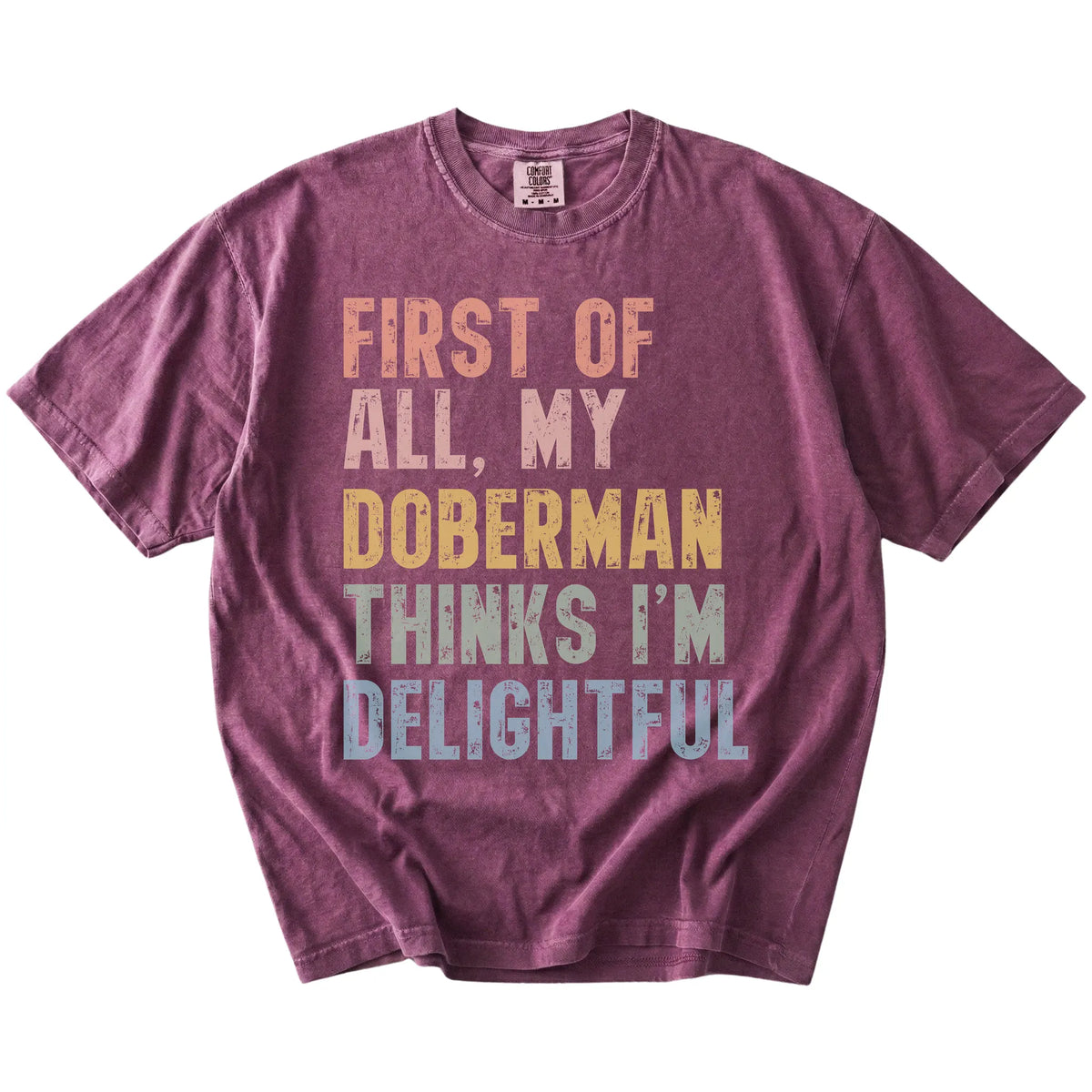 “My Doberman thinks I’m delightful” text on a Berry Comfort Colors® T-shirt