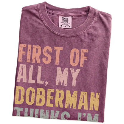 Folded Berry Comfort Colors® T-shirt showing “My Doberman thinks I’m delightful” text