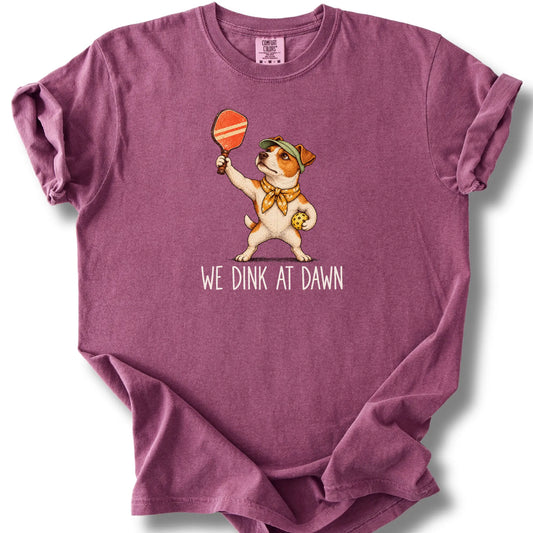 Jack Russell with a pickleball paddle and ball on a Berry Comfort Colors® T-shirt with We Dink at Dawn text