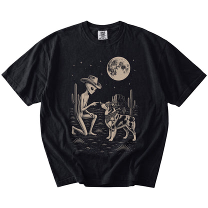Cowboy alien fist-bumping a Australian Shepherd beneath the moon on a Black Comfort Colors® T-shirt