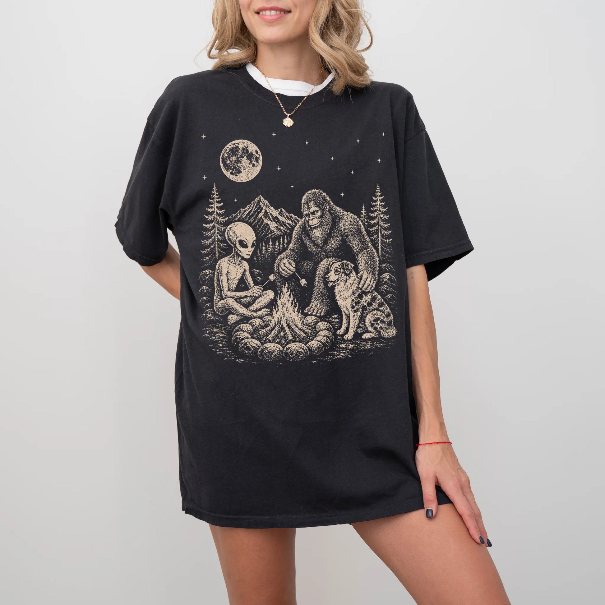 Model wearing a Black Comfort Colors® T-shirt showing Australian Shepherd camping with Bigfoot and an alien