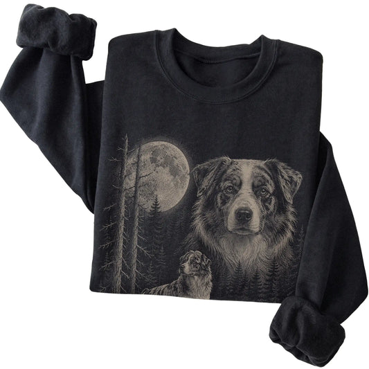 Folded black crewneck sweatshirt showing the Australian Shepherd Moonlit Forest graphic
