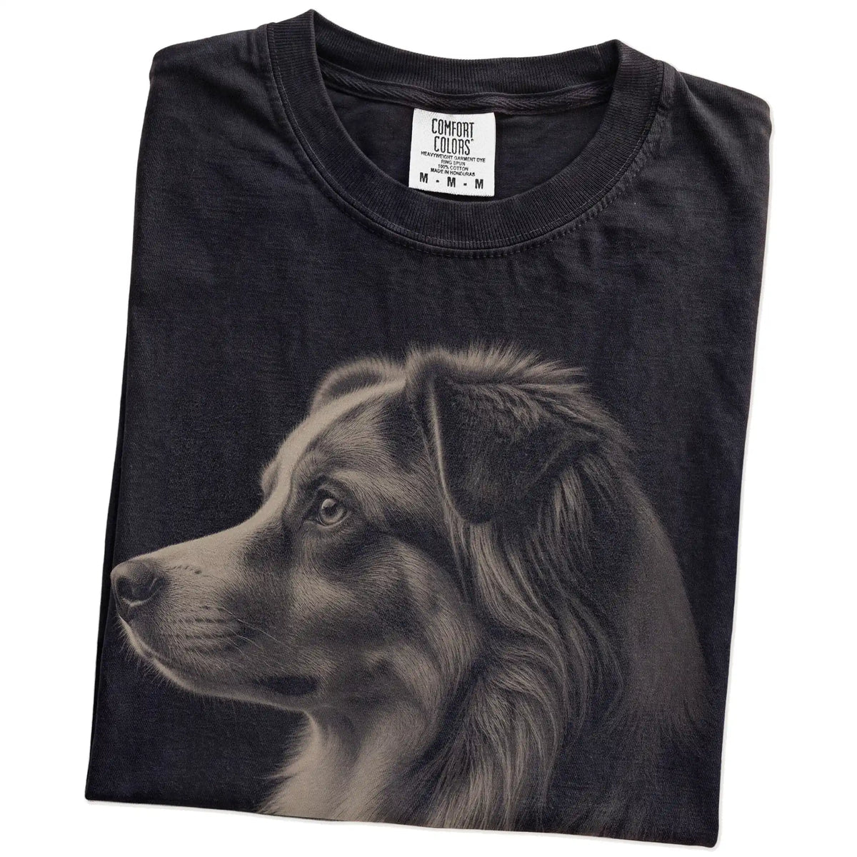 Folded Black Comfort Colors® T-shirt showing a detailed photographic portrait of a Australian Shepherd