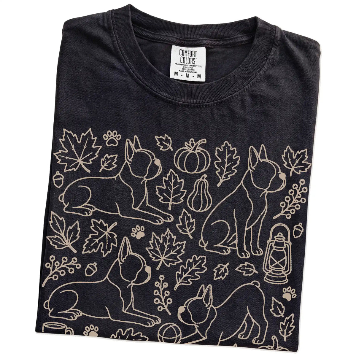 Folded Black Comfort Colors® T-shirt showing Boston Terrier dogs with pumpkins, leaves, acorns, and woodland details
