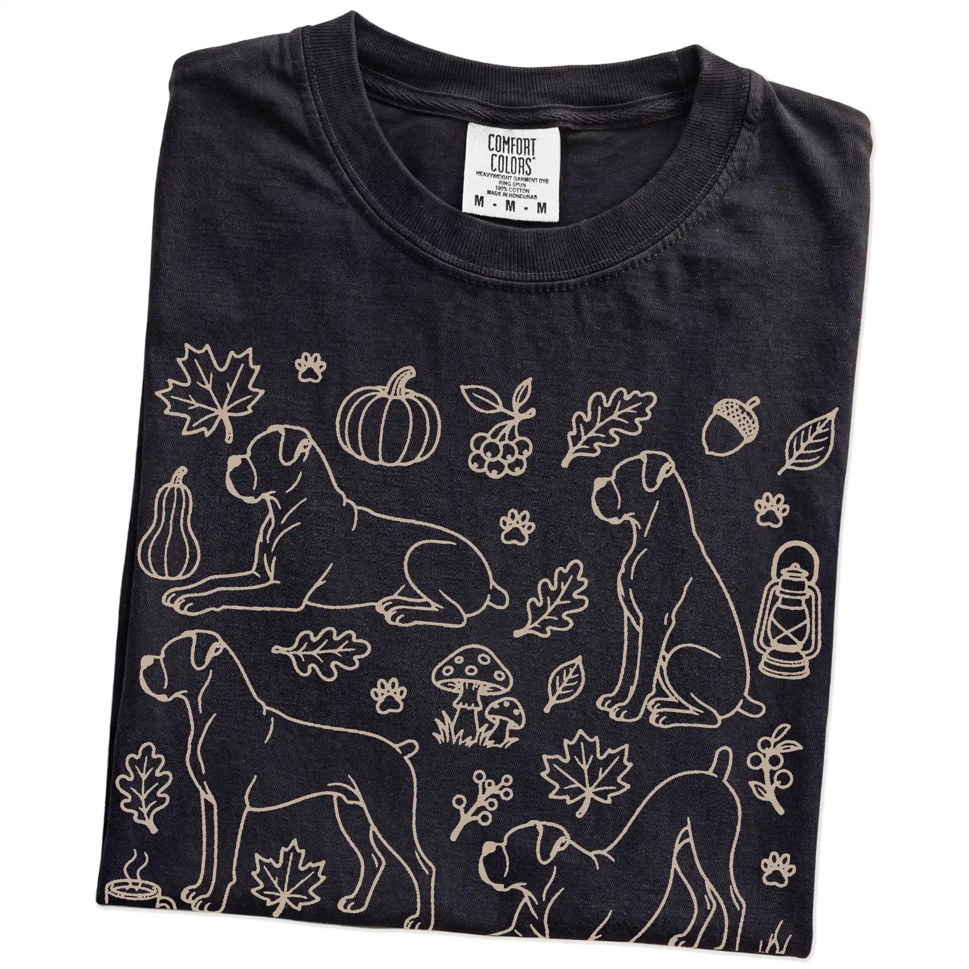 Folded Black Comfort Colors® T-shirt showing Boxer dogs with pumpkins, leaves, acorns, and woodland details