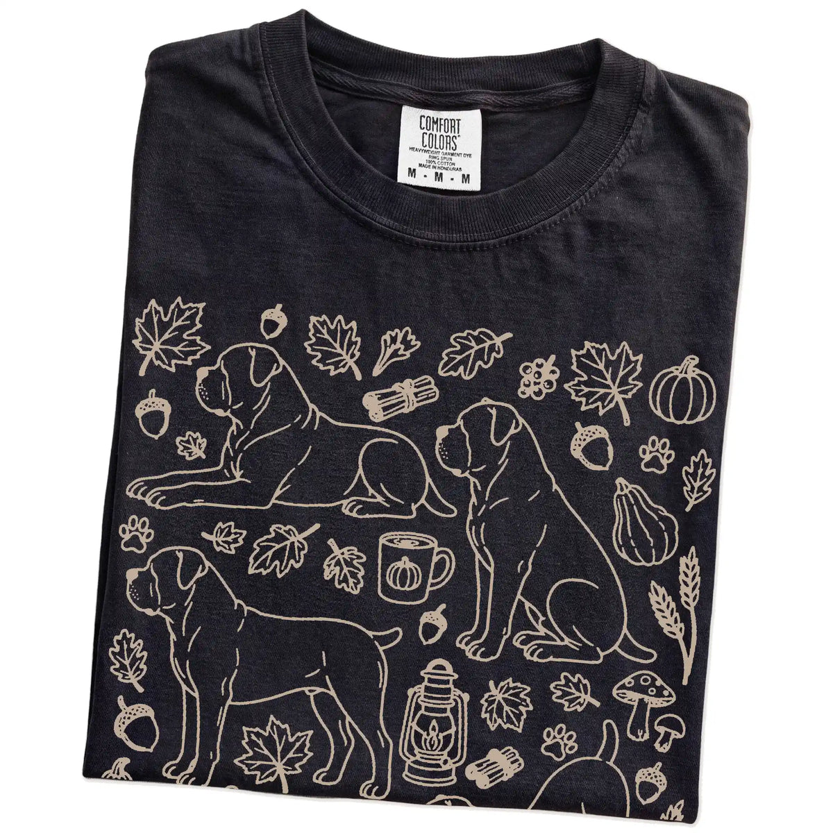 Folded Black Comfort Colors® T-shirt showing Cane Corso dogs with pumpkins, leaves, acorns, and woodland details