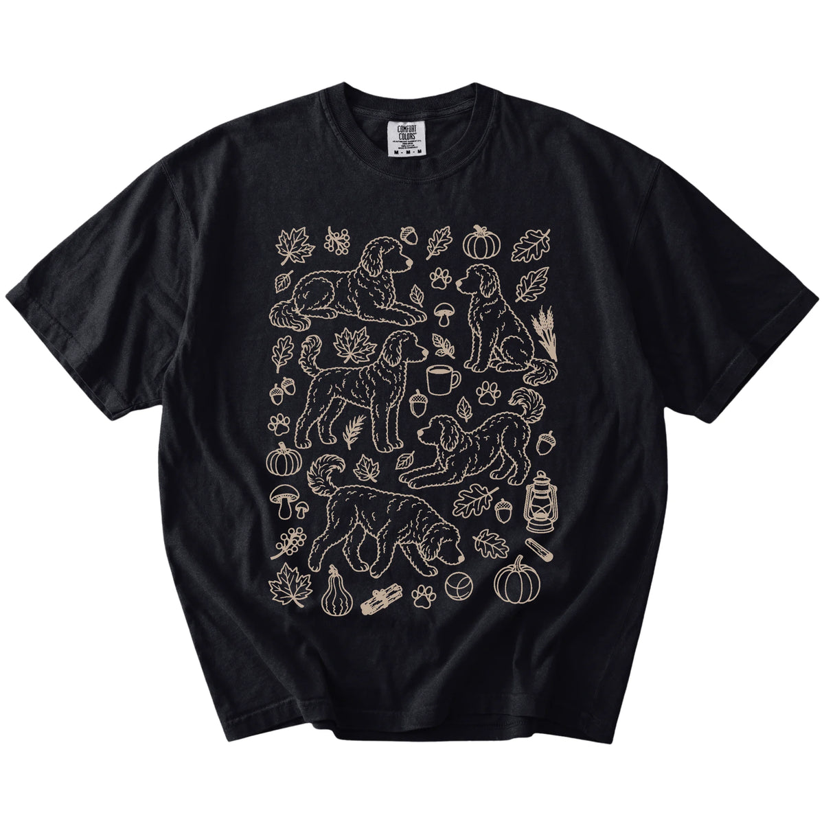 Goldendoodle dogs with pumpkins, leaves, acorns, and woodland details on a Black Comfort Colors® T-shirt