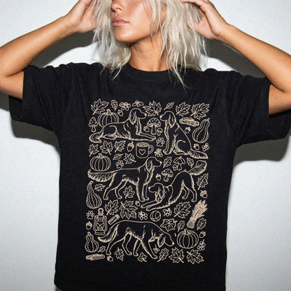 Model wearing a Black Comfort Colors® T-shirt with Irish Setter dogs with pumpkins, leaves, acorns, and woodland details