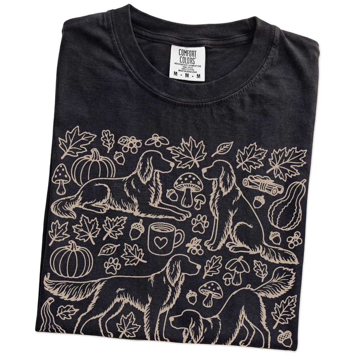 Folded Black Comfort Colors® T-shirt showing Irish Setter dogs with pumpkins, leaves, acorns, and woodland details