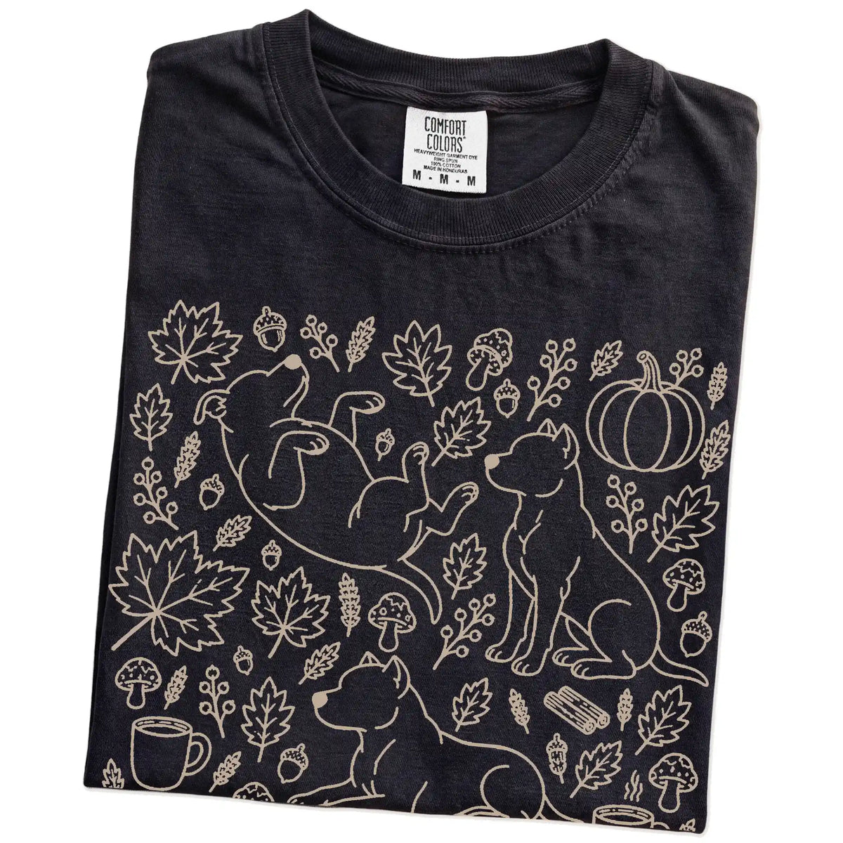 Folded Black Comfort Colors® T-shirt showing Pitbull dogs with pumpkins, leaves, acorns, and woodland details