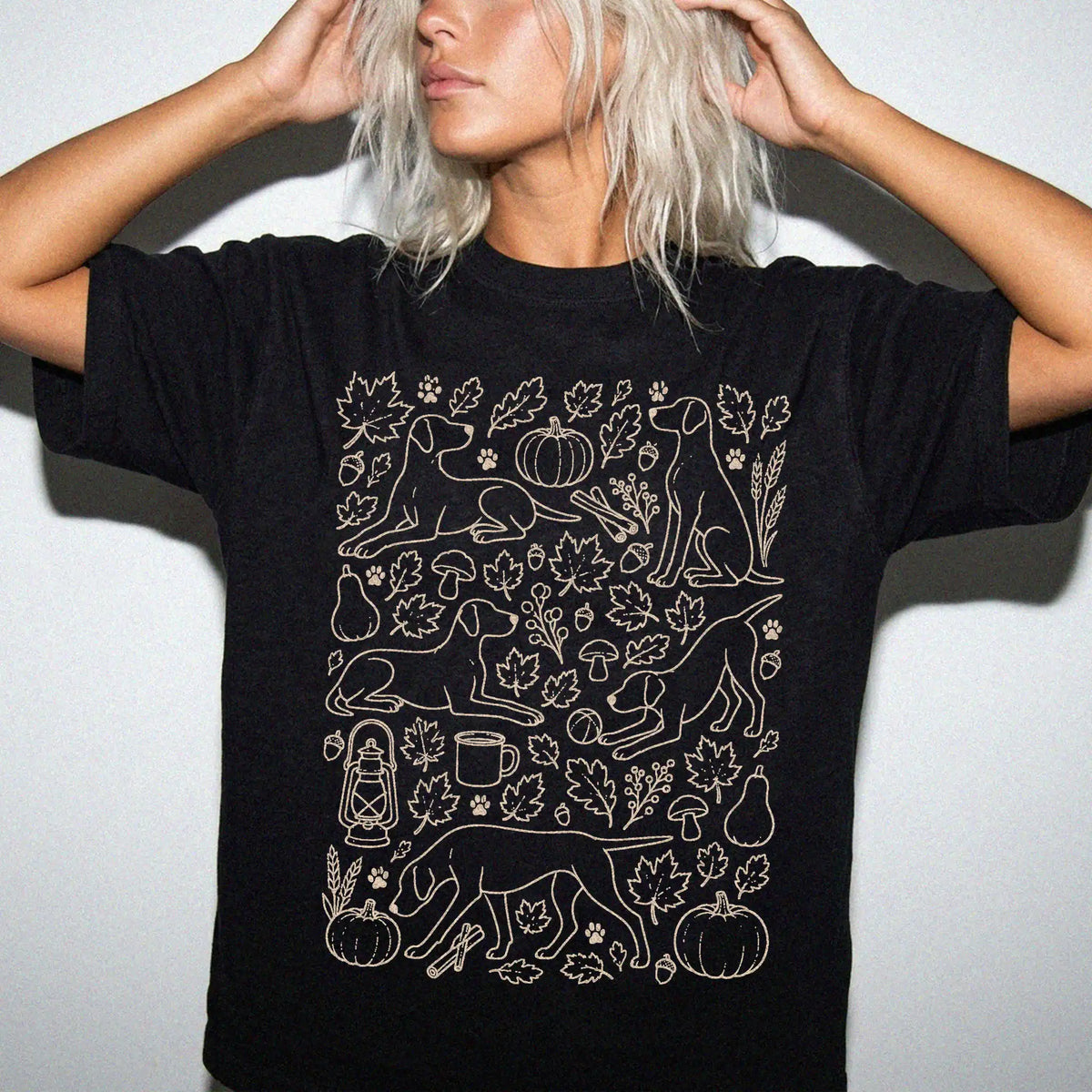 Model wearing a Black Comfort Colors® T-shirt with Pointer dogs with pumpkins, leaves, acorns, and woodland details