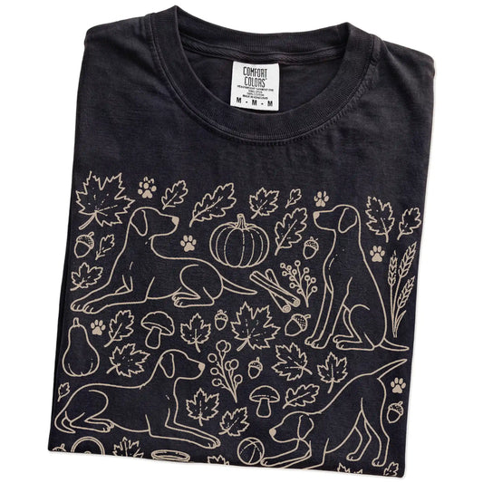 Folded Black Comfort Colors® T-shirt showing Pointer dogs with pumpkins, leaves, acorns, and woodland details