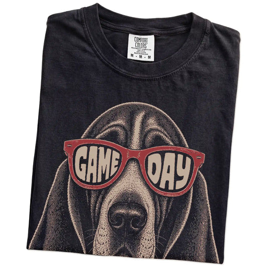 Folded Black Comfort Colors® T-shirt showing basset hound wearing red game day sunglasses