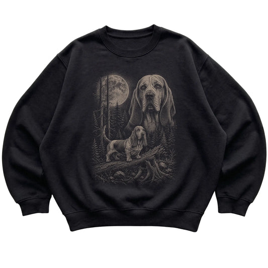 Basset Hound Moonlit Forest graphic on a black crewneck sweatshirt laid flat