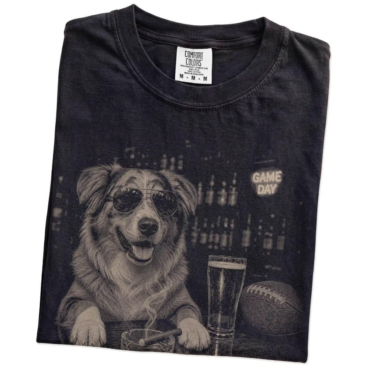 Folded Black Comfort Colors® T-shirt showing Australian Shepherd with beer and football graphics