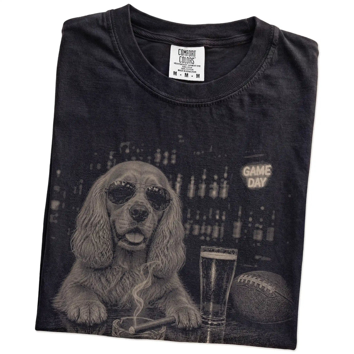 Folded Black Comfort Colors® T-shirt showing Cocker Spaniel with beer and football graphics