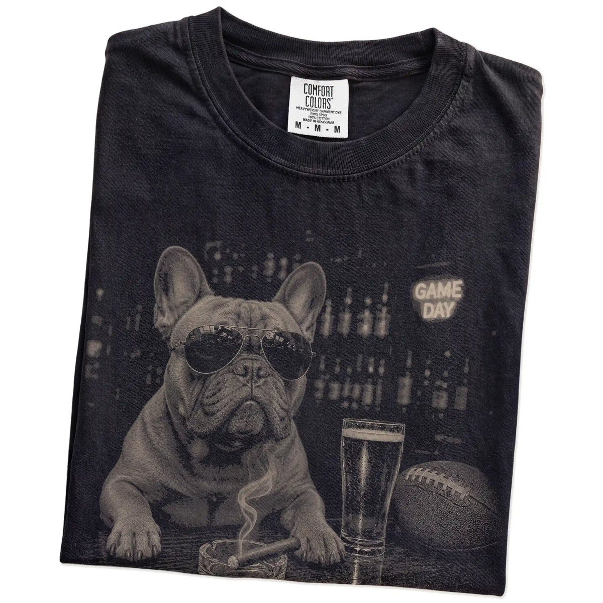 Folded Black Comfort Colors® T-shirt showing French Bulldog with beer and football graphics