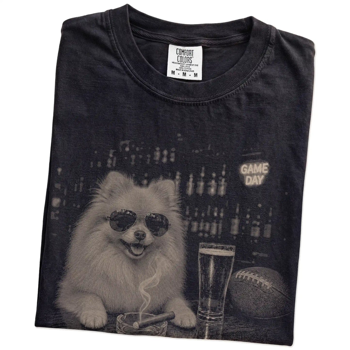Folded Black Comfort Colors® T-shirt showing Pomeranian with beer and football graphics