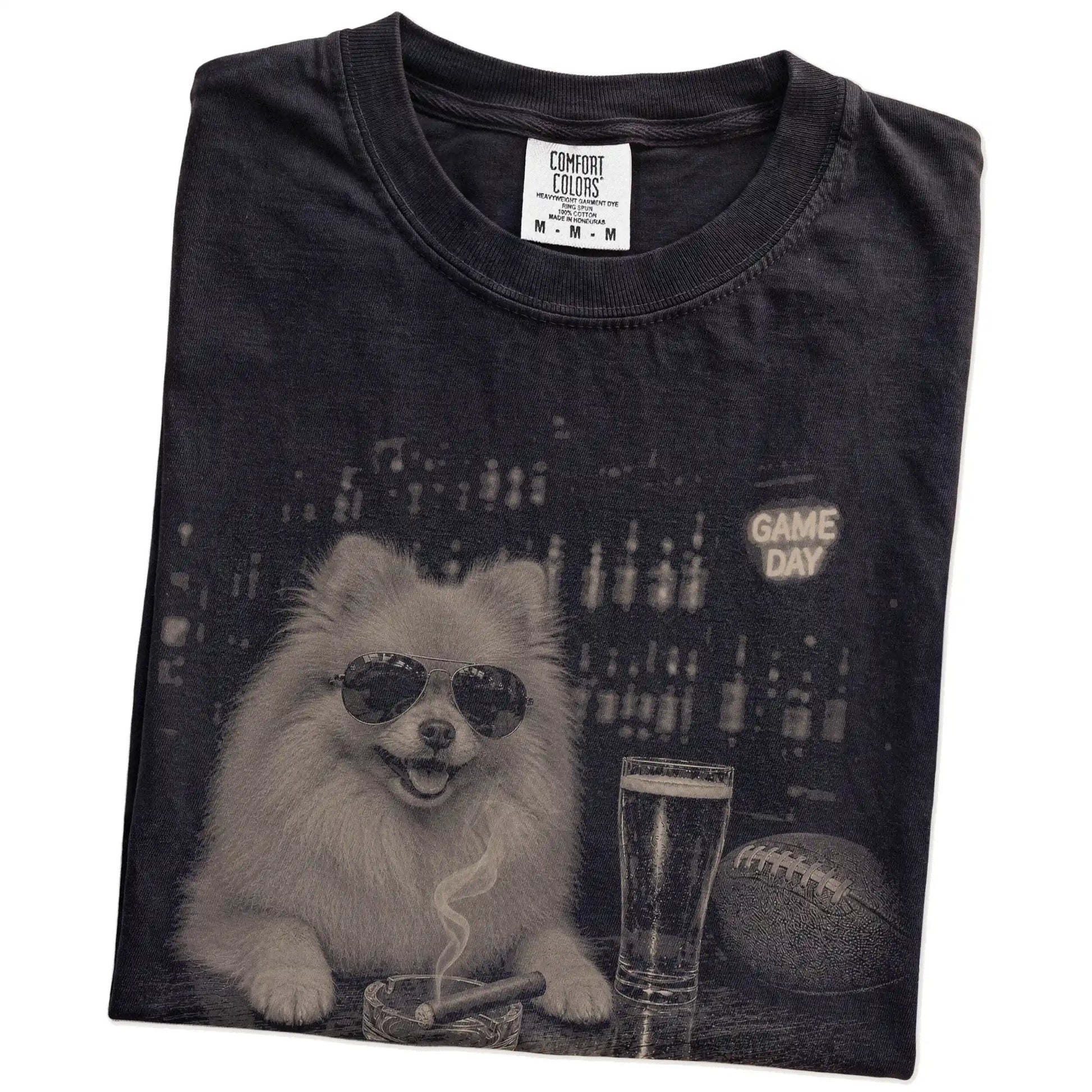 Folded Black Comfort Colors® T-shirt showing Pomeranian with beer and football graphics