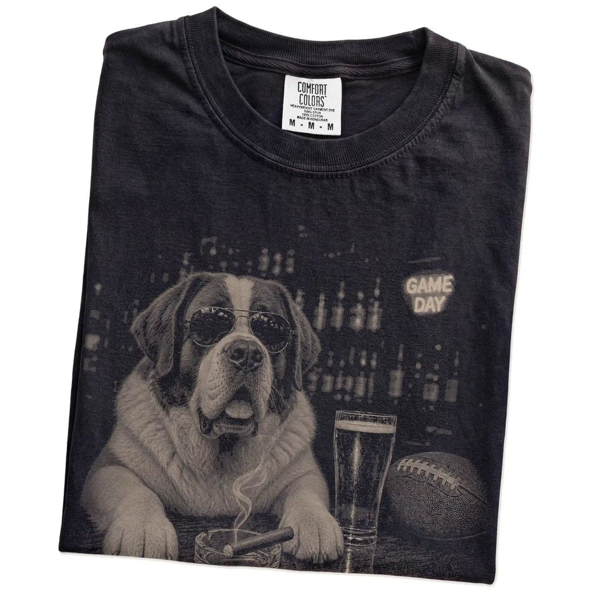 Folded Black Comfort Colors® T-shirt showing Saint Bernard with beer and football graphics