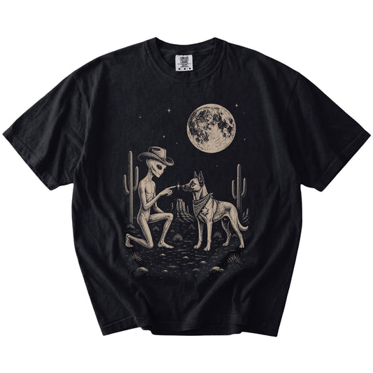 Cowboy alien fist-bumping a Belgian Malinois beneath the moon on a Black Comfort Colors® T-shirt
