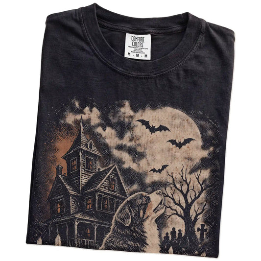 Folded Black Comfort Colors® T-shirt showing Bernese Mountain Dog in a vintage haunted-house scene