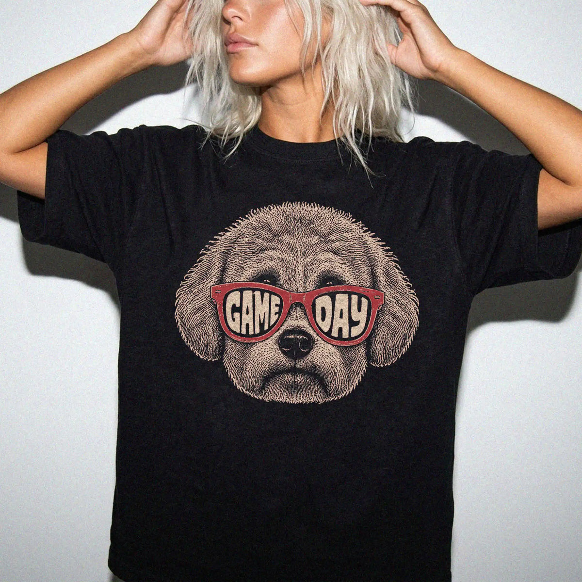 Model wearing a Black Comfort Colors® T-shirt with bichon frise wearing red game day sunglasses