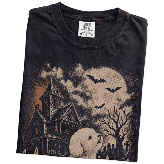 Folded Black Comfort Colors® T-shirt showing Bichon Frise in a vintage haunted-house scene
