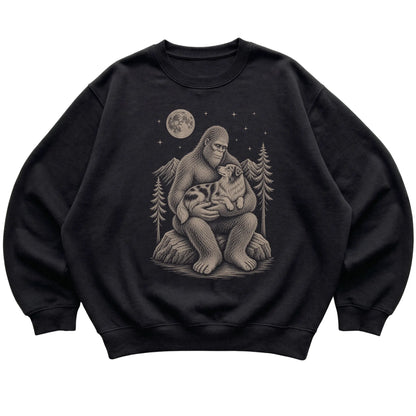 Black crewneck sweatshirt with Bigfoot holding an Australian Shepherd under a moonlit sky