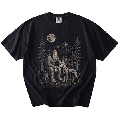 Bigfoot petting a Weimaraner beneath the moon in a pine forest on a Black Comfort Colors® T-shirt