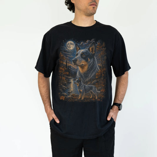 Model wearing a Black Comfort Colors® t-shirt featuring Blue Heeler in a moonlit fall forest