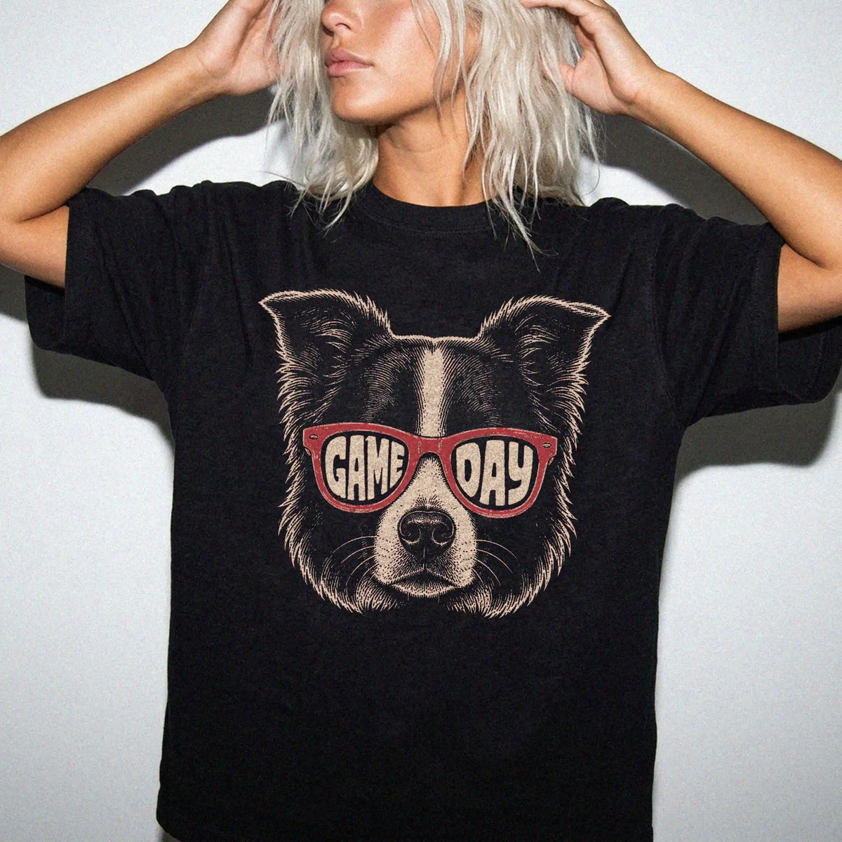 Model wearing a Black Comfort Colors® T-shirt with border collie wearing red game day sunglasses