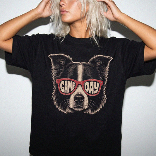 Model wearing a Black Comfort Colors® T-shirt with border collie wearing red game day sunglasses