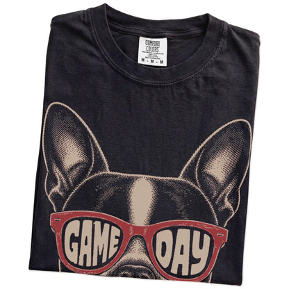 Folded Black Comfort Colors® T-shirt showing boston terrier wearing red game day sunglasses