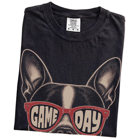 Folded Black Comfort Colors® T-shirt showing boston terrier wearing red game day sunglasses