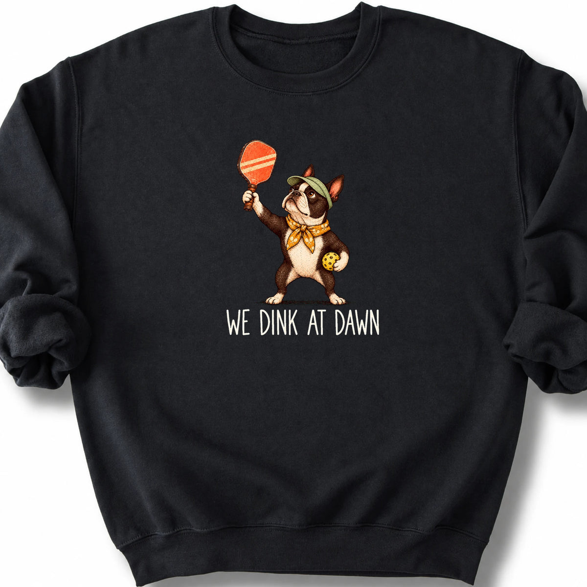 Boston Terrier with a pickleball paddle and ball on a Black Gildan® sweatshirt with We Dink at Dawn text