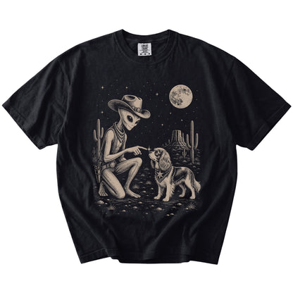 Cowboy alien fist-bumping a Cavalier King Charles Spaniel beneath the moon on a Black Comfort Colors® T-shirt