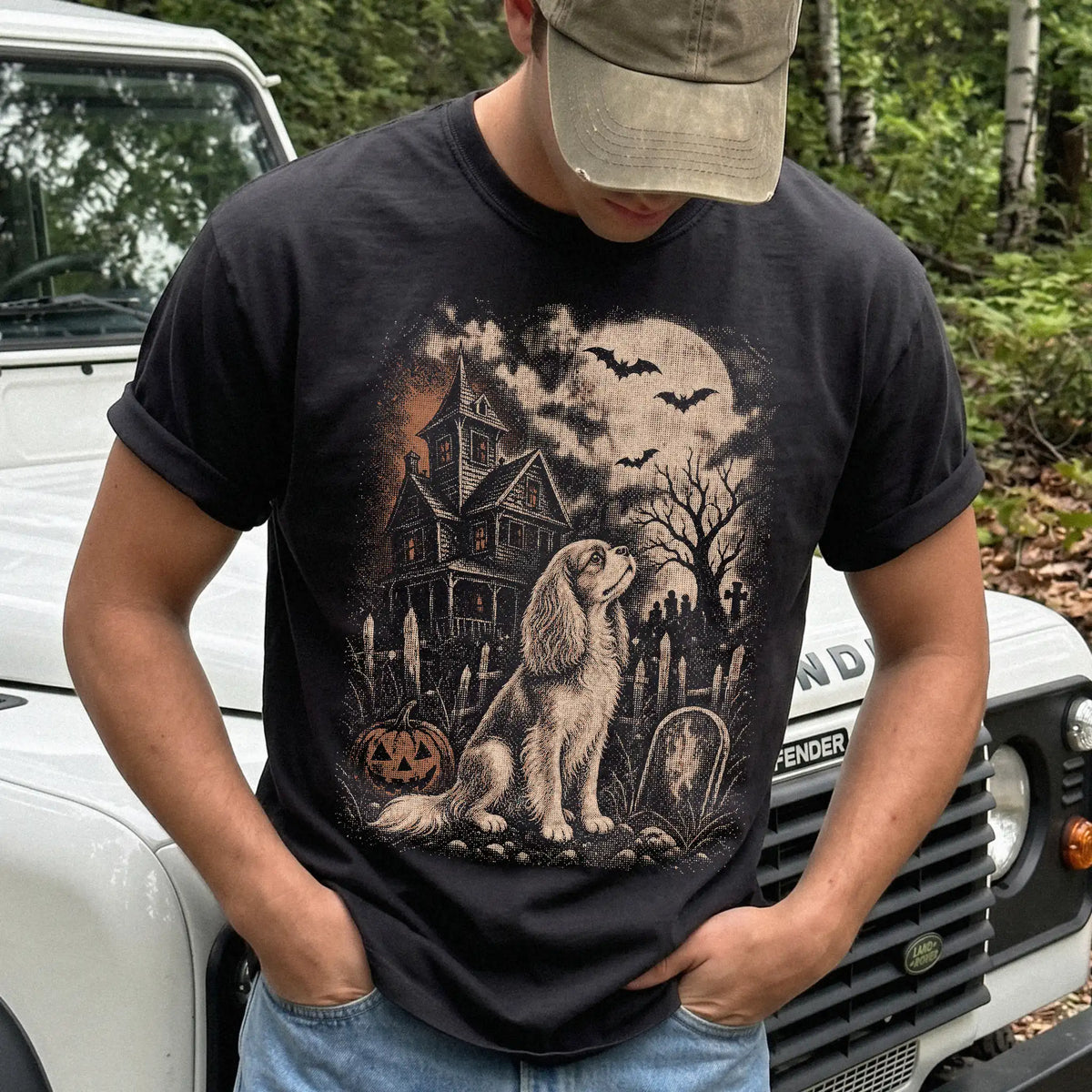 Model wearing a Black Comfort Colors® T-shirt showing Cavalier King Charles Spaniel in a vintage haunted-house scene