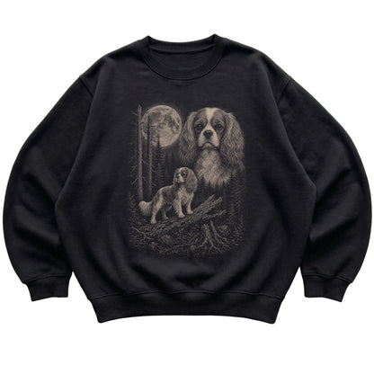 Cavalier King Charles Spaniel Moonlit Forest graphic on a black crewneck sweatshirt laid flat