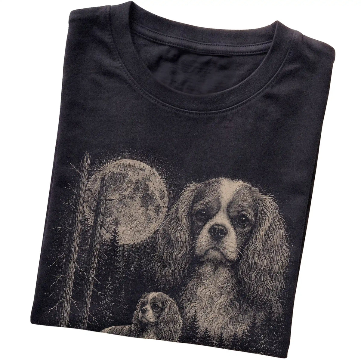 Folded black Softstyle T-shirt showing the Cavalier King Charles Spaniel Moonlit Forest graphic