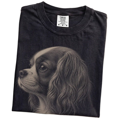 Folded Black Comfort Colors® T-shirt showing a detailed photographic portrait of a Cavalier King Charles Spaniel
