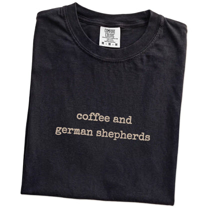 Folded Black Comfort Colors® T-shirt showing “coffee and german shepherds” retro text