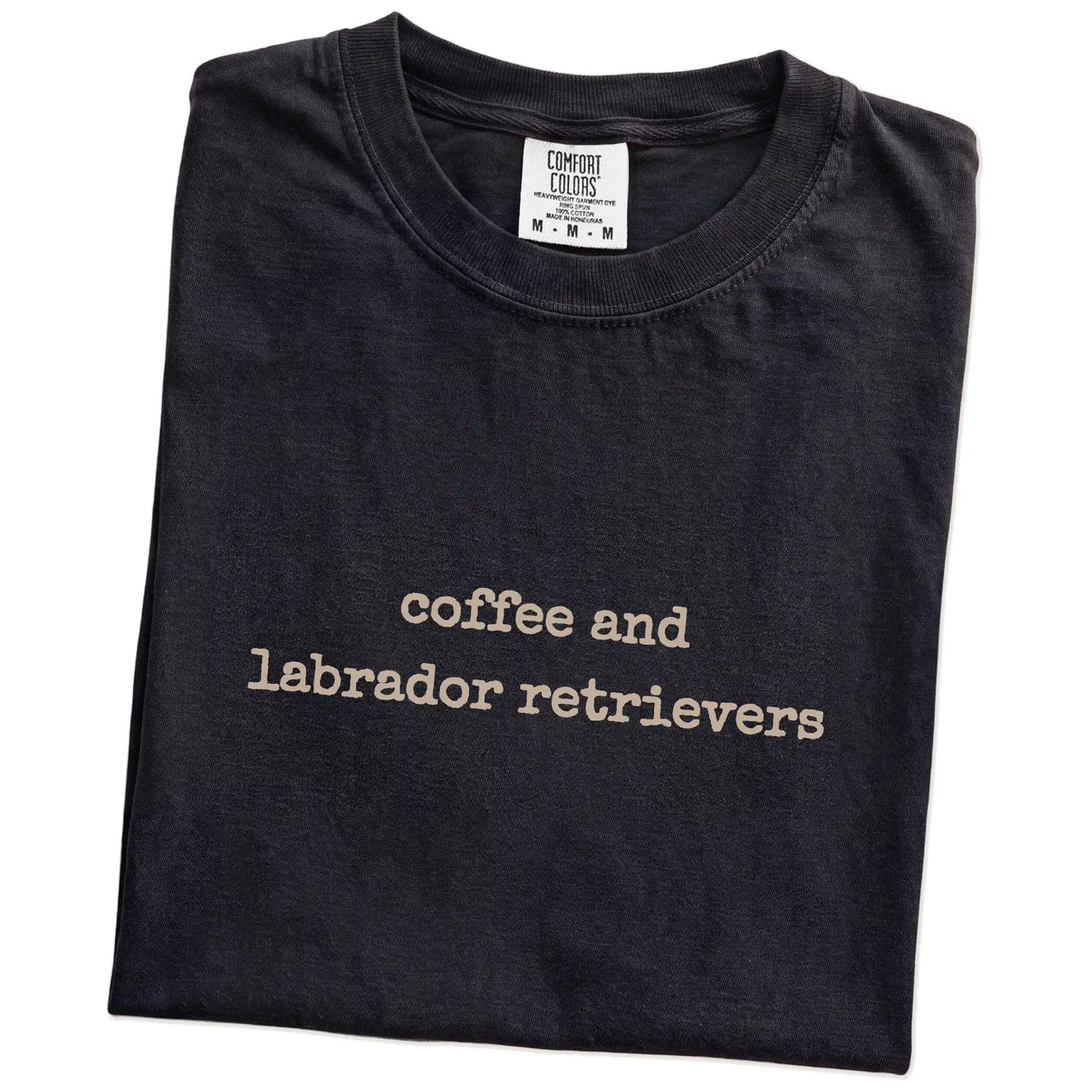 Folded Black Comfort Colors® T-shirt showing “coffee and labrador retrievers” retro text